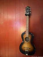 Full front view of Framus sunburst acoustic guitar hanging on wall