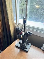 Full view of black speckled poodle lamp on table