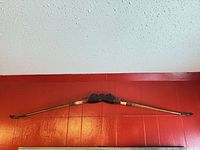 Full view of bow mounted on wall showing entire length and overall condition