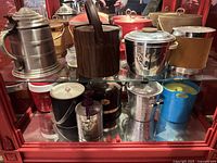 Entire collection displayed on two shelves showing variety of ice buckets