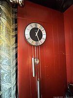 Full view of wall clock with weights and chains