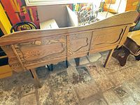 Rear view of carved wood headboard showing overall design, grain, legs
