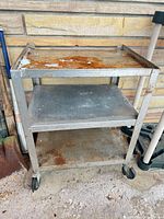 Full view of metal utility cart, three shelves, casters