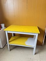 Overall view of wood desk showing yellow top and white frame