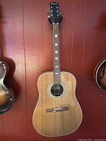 Full front view of Regent acoustic guitar hanging on wall