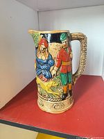 Front view showing figural scene and handle