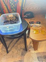 Overview showing tub of sunglasses on chair and additional pairs on table