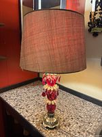 Full view of lamp with shade showing red prisms and brass base