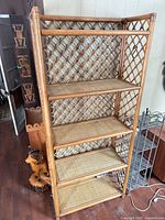 Front view of tall rattan bookshelf showing five shelves and lattice sides