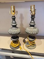 Front view of both bronze-tone lamps showing overall form and sockets