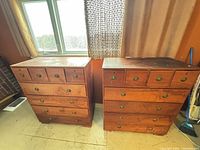 Front view of both teak highboy dressers showing eight-drawer configuration