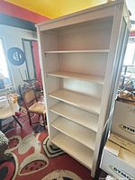 Front view of one white bookcase showing shelves and overall condition