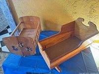 Two wooden doll cradles side by side