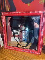 Front view of Elvis Presley portrait mirror in red frame