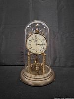Front view of Black Forest anniversary clock under glass dome