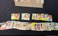 Overview of full storage box packed with vintage baseball cards and sample cards laid out in front