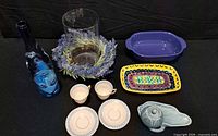 All items laid out: CorningWare baker, platter, vase with wreath, bottle, fish dish, two teacups with saucers