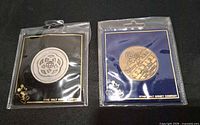 Front view of both packaged Walt Disney commemorative coins