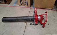 Side view of red Toro electric blower with black tube attached