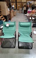 Front view of both green folding lounge chairs