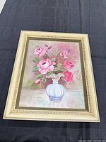 Front view showing floral painting, signature, and gilt frame