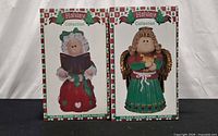 Front view of two Holiday Collection boxes for Angel and Mrs. Santa figurines