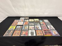 Full overhead view of all 28 CDs arranged in four rows on black surface