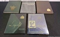 Five Loyola yearbooks assorted colours front covers visible