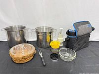 All items grouped: stock pots, insert, glass casserole in wicker basket, utensils, Igloo cooler bag