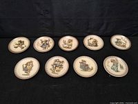 Overview of all nine M.J. Hummel saucers displayed face up