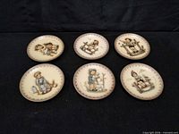Six Hummel saucers arranged, full set visible