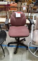 Front view of brown swivel office chair with armrests and casters