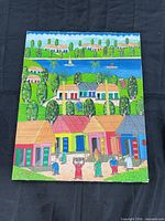 Full view of colorful Caribbean village scene painting on stretched canvas