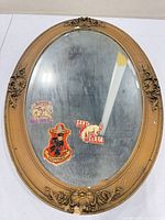 Front view of the oval gilt Rococo mirror showing frame details, glass condition, and stickers