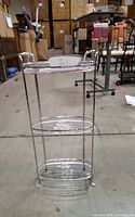 Full view of chrome metal plant stand showing three tiers and overall structure