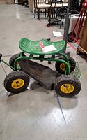 Side view of rolling garden cart showing seat, wheels, tray, basket