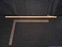 Wooden yardstick and steel carpenter’s square displayed