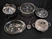 Group of silver-plated covered dishes, oval platter, glass bowl in stand and ladle
