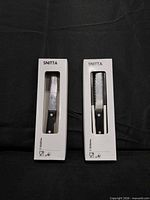 Two boxed Snitta knives, straight and serrated, front view