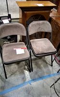 Two upholstered folding chairs side by side