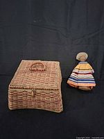 Wicker sewing basket closed next to cloth doll