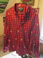 Front view of red/navy plaid shirt with embroidered Steal Your Face logos
