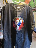 Front view of black T-shirt on hanger showing full embroidered design