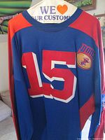 Front view of blue jersey showing number 15 and Dons patch