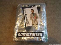 Factory-sealed package showing folded silver sequin jacket with Suitmeister branding