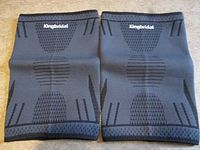 Pair of grey and black Kingbridal knee sleeves laid flat