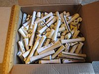 Open box filled with white perm rods showing quantity and style