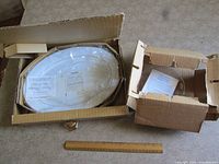 Opened boxes with porcelain platter, crystal bowl and ruler for scale