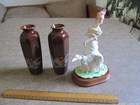 Overview showing two vases, figurine and ruler for scale