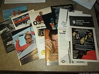 Spread of assorted single-page Playboy advertisements laid out on table